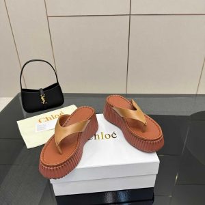 Elegant black Chloé Woody Sandals, showcasing platform thong sandals with their signature ribbed sole, perfect for luxury casual looks.