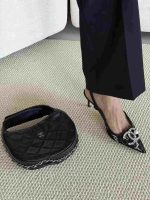 A sophisticated black embellished Chanel Slingback Heel worn on foot, next to a quilted Chanel handbag, highlighting the luxury pointed toe heel and elegant design perfect for evening occasions.