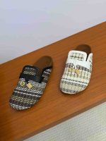 Louis Vuitton Lock It raffia mules in white, brown, and black with leather strap and gold LV padlock charm.