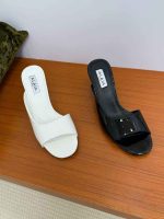 ALAÏA slide sandals on a wooden surface