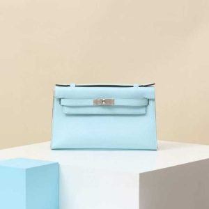 Light blue Hermès Kelly Pochette leather clutch bag on pedestal