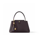 Beige leather tote bag with beaded charm and top handle