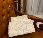 A collage of three images. The top image shows a person holding a woven straw tote bag with a large, embroidered white floral design.