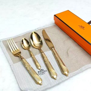 Luxury stainless steel cutlery set with spoon, fork, and knife on marble table