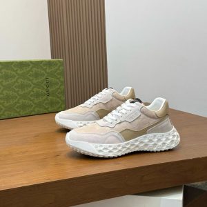 A pair of Gucci Rhyton sneakers in beige and brown GG Supreme canvas, featuring a chunky white rubber sole and lace-up closure.