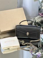 Collection of elegant handbags in various colors displayed on a table.