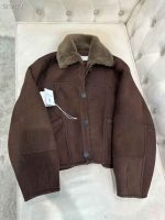 A close-up of a light brown and a dark brown shearling bomber jacket with prominent sheepskin collars and cuffs.