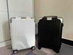 White and black hard shell suitcases side by side on a floor.