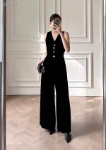 Elegant black velvet jumpsuit with gold buttons and earrings, perfect for stylish occasions.